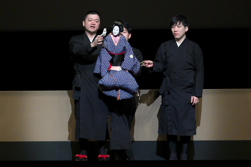 【Aプロ】三人遣いの説明をする人形遣い（左から主遣い、足遣い、左遣い）