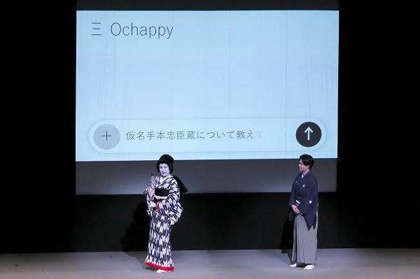 解説をする市川おとらとスクリーンに表示されるスマートフォンの画面