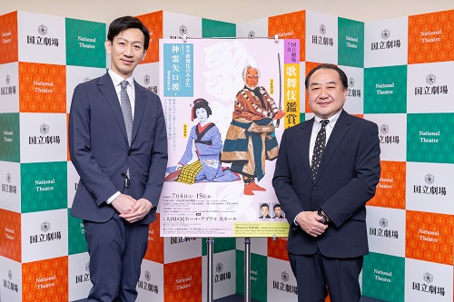 写真：公演ポスターを背景に並ぶ坂東しんご、中村がんじろうの集合写真