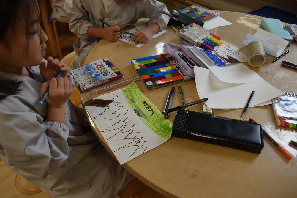 下が険しい山、上が緑になっていて爬虫類がいる絵