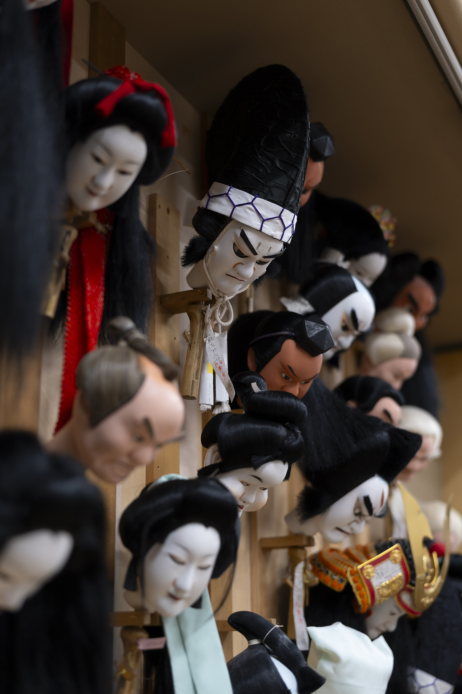 2月文楽公演で用いられる様々なかしらが掛けられた壁