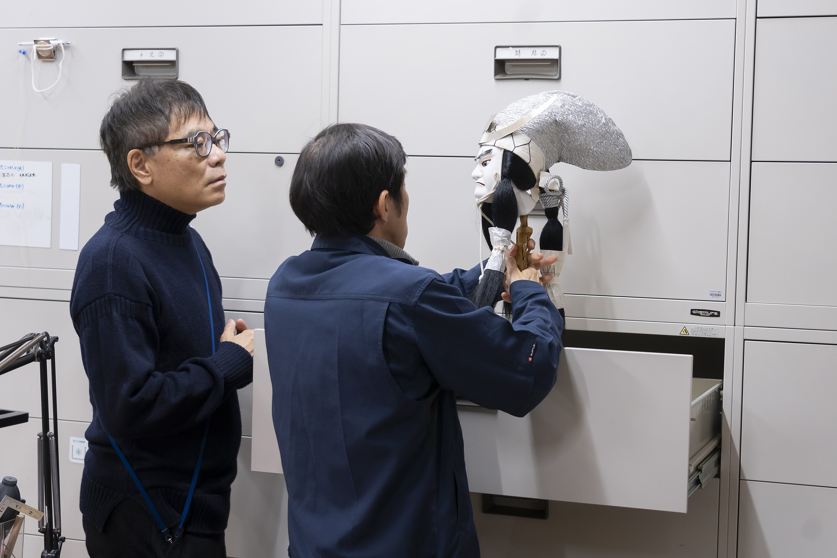 知盛のかしらを手に仕掛けの説明をする村尾