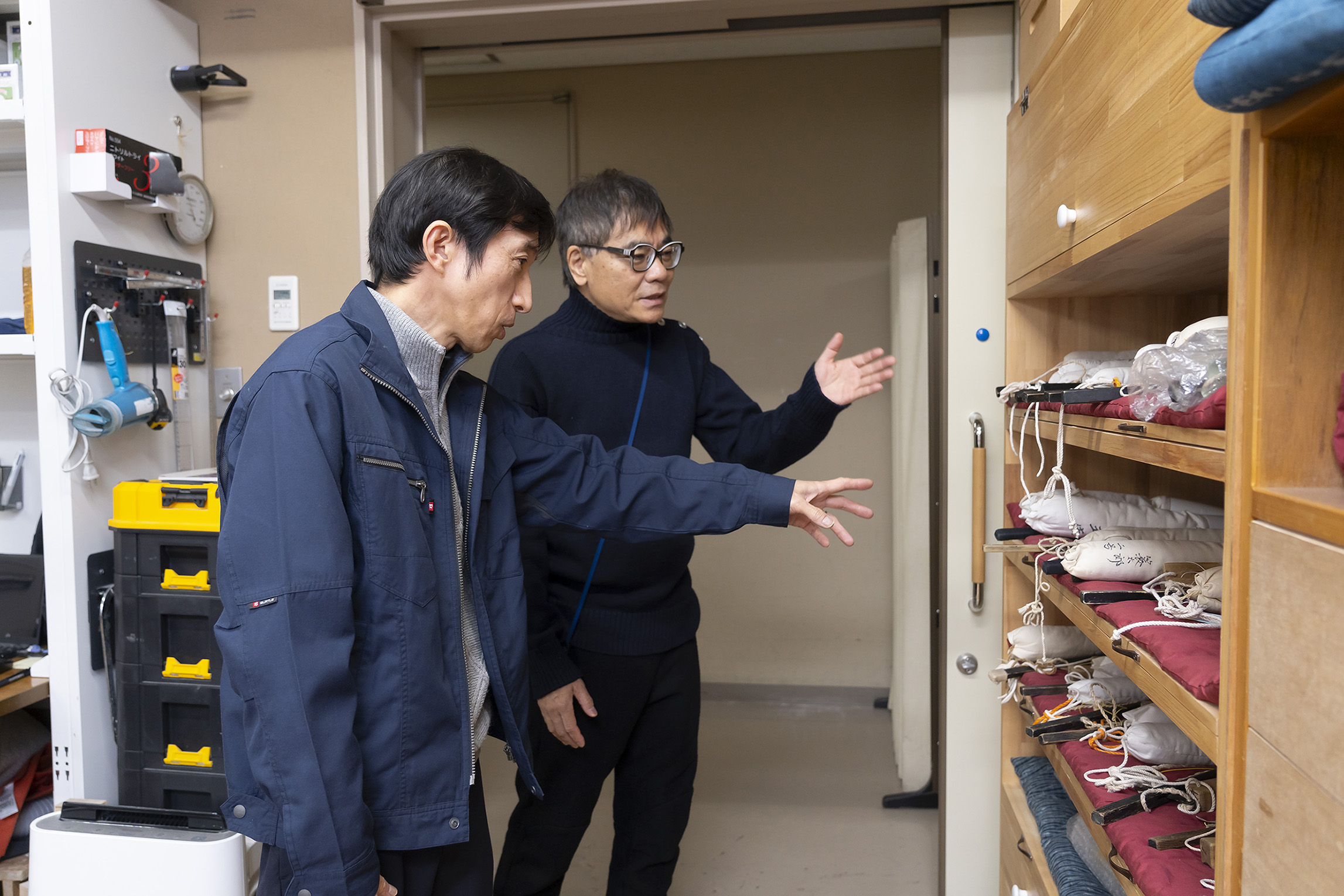 入口近くの、人形の手足が置かれている棚について尋ねるいとうせいこうと答える村尾室長