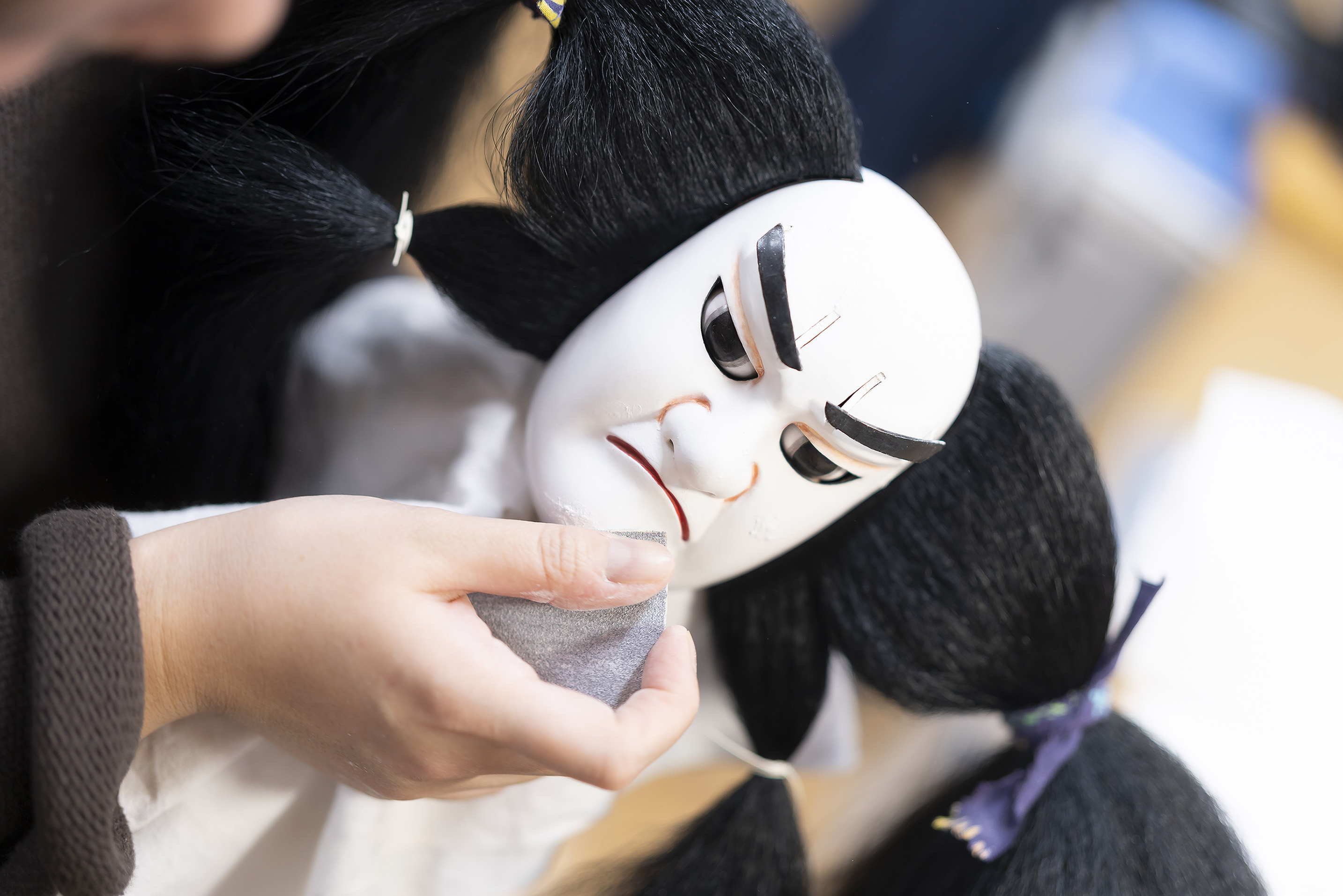 かしらの顎のあたりの手入れをしている職員B