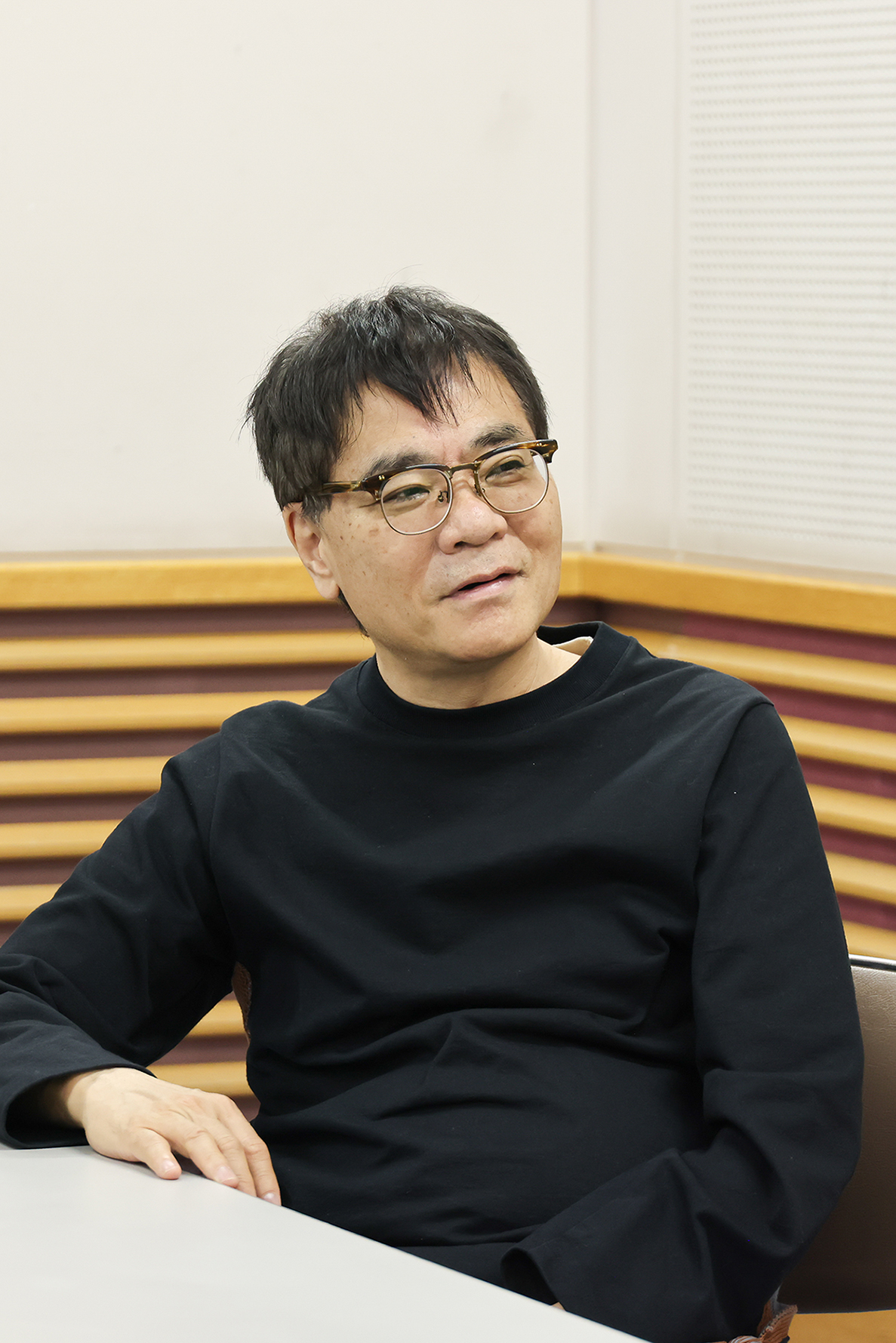 微笑みをたたえながら話に聞き入るいとうせいこう"